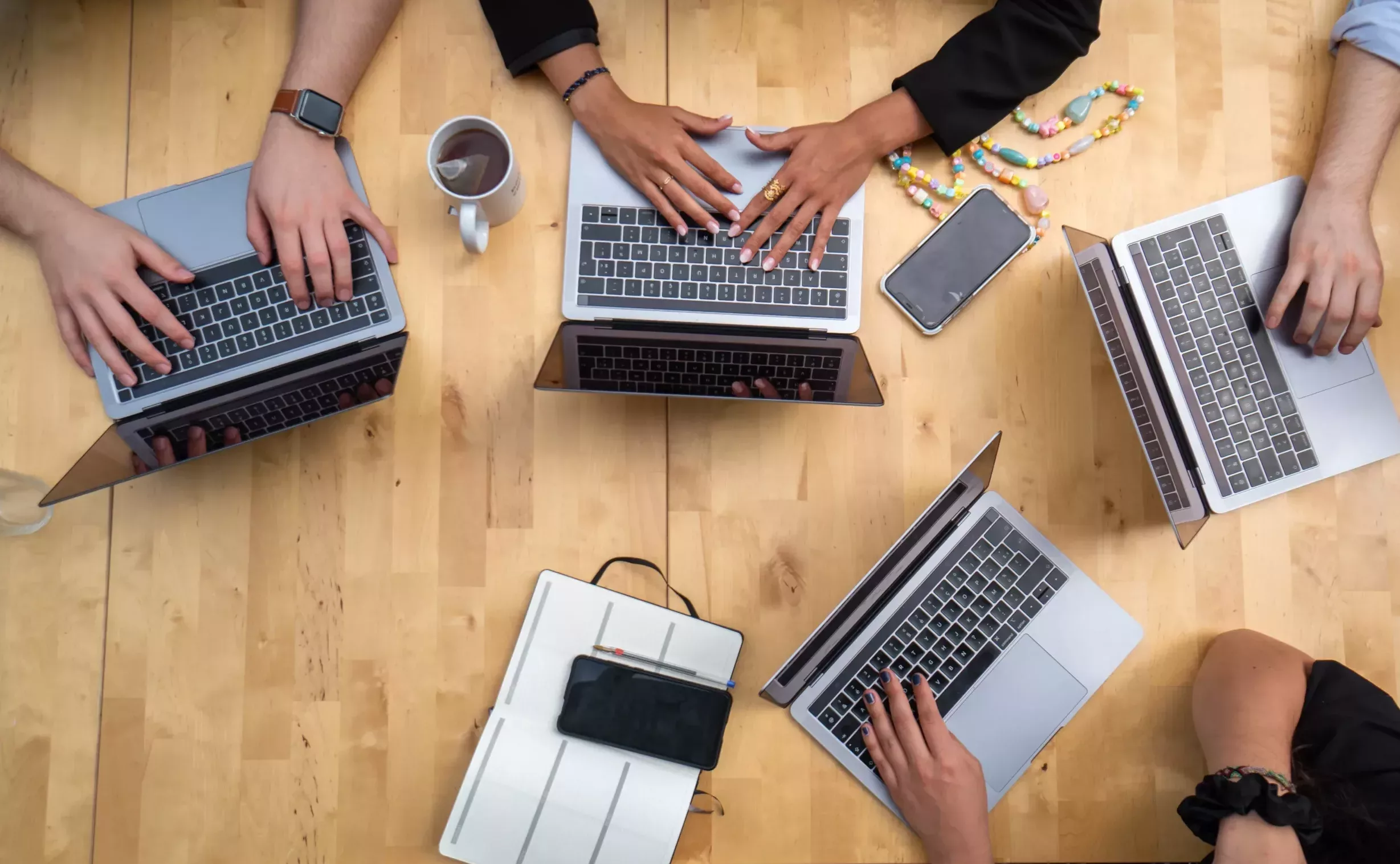 Agentur-Team arbeitet gemeinsam an Laptops